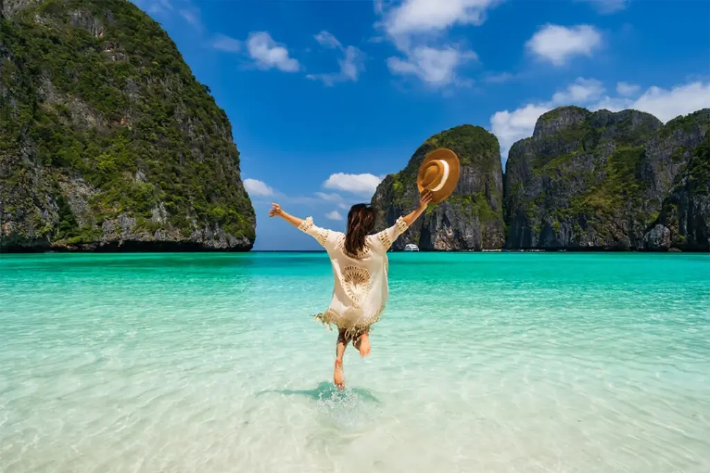 Traveler standing in shallow water at Maya Bay in the Phi Phi Islands